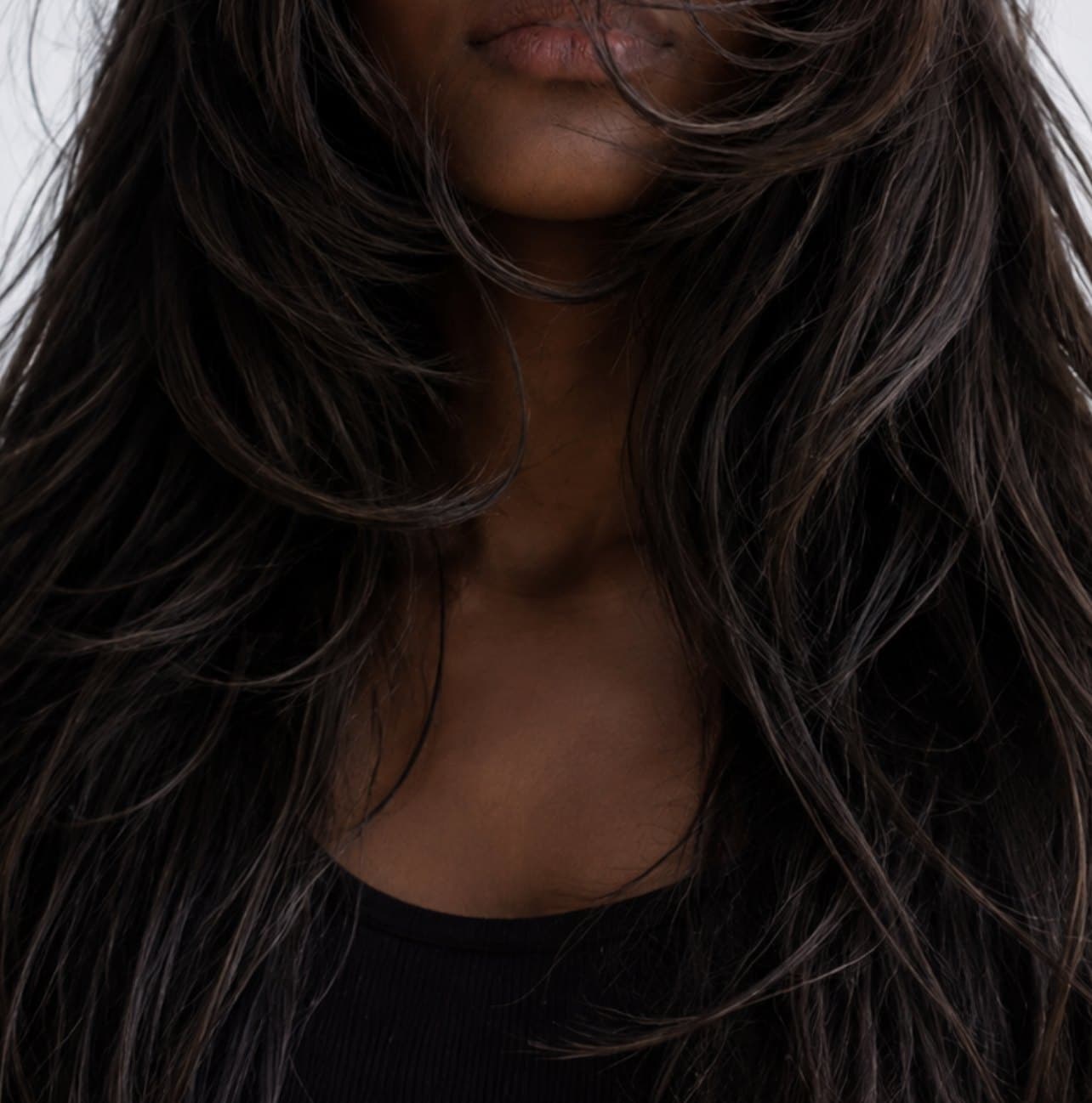 A woman with long dark hair blowing across her face