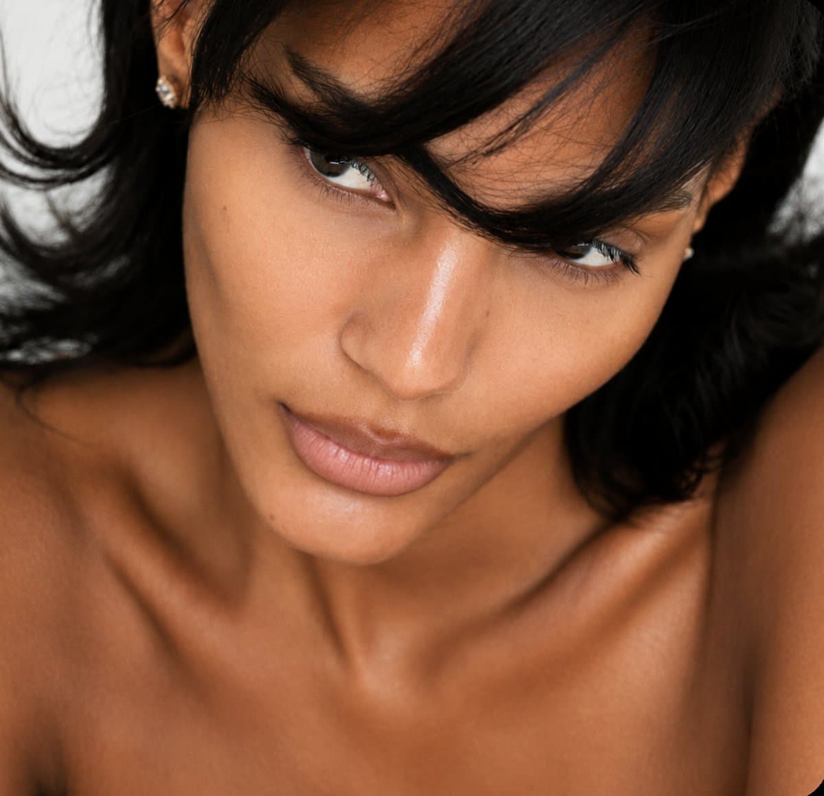 A woman with dark hair glancing downward, black and white editorial portrait