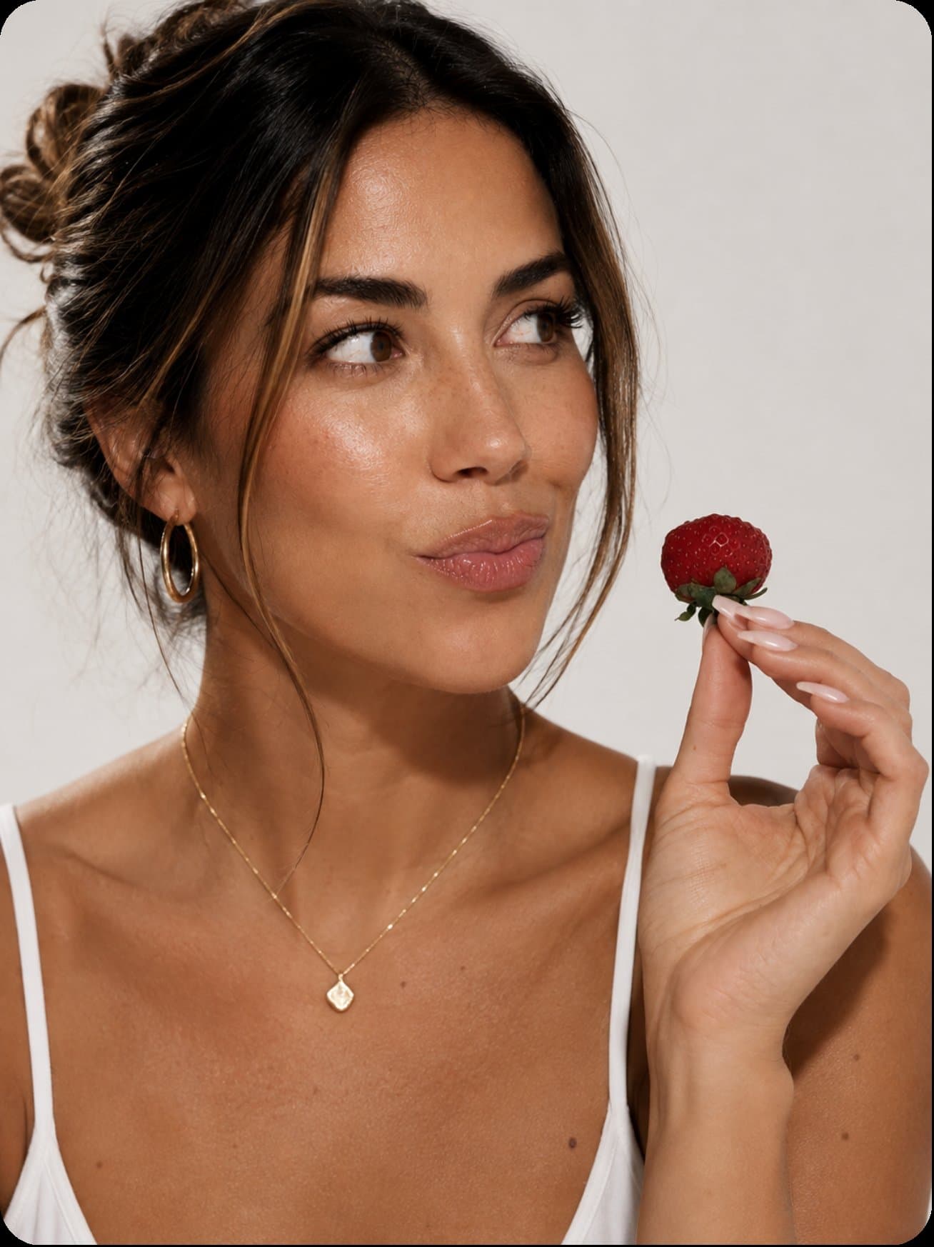 A woman holding a strawberry
