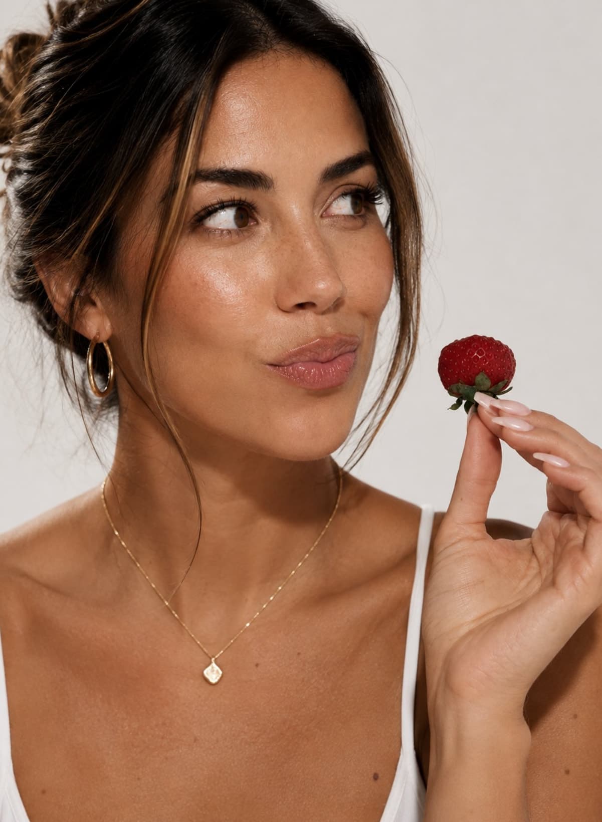 A woman holding a strawberry