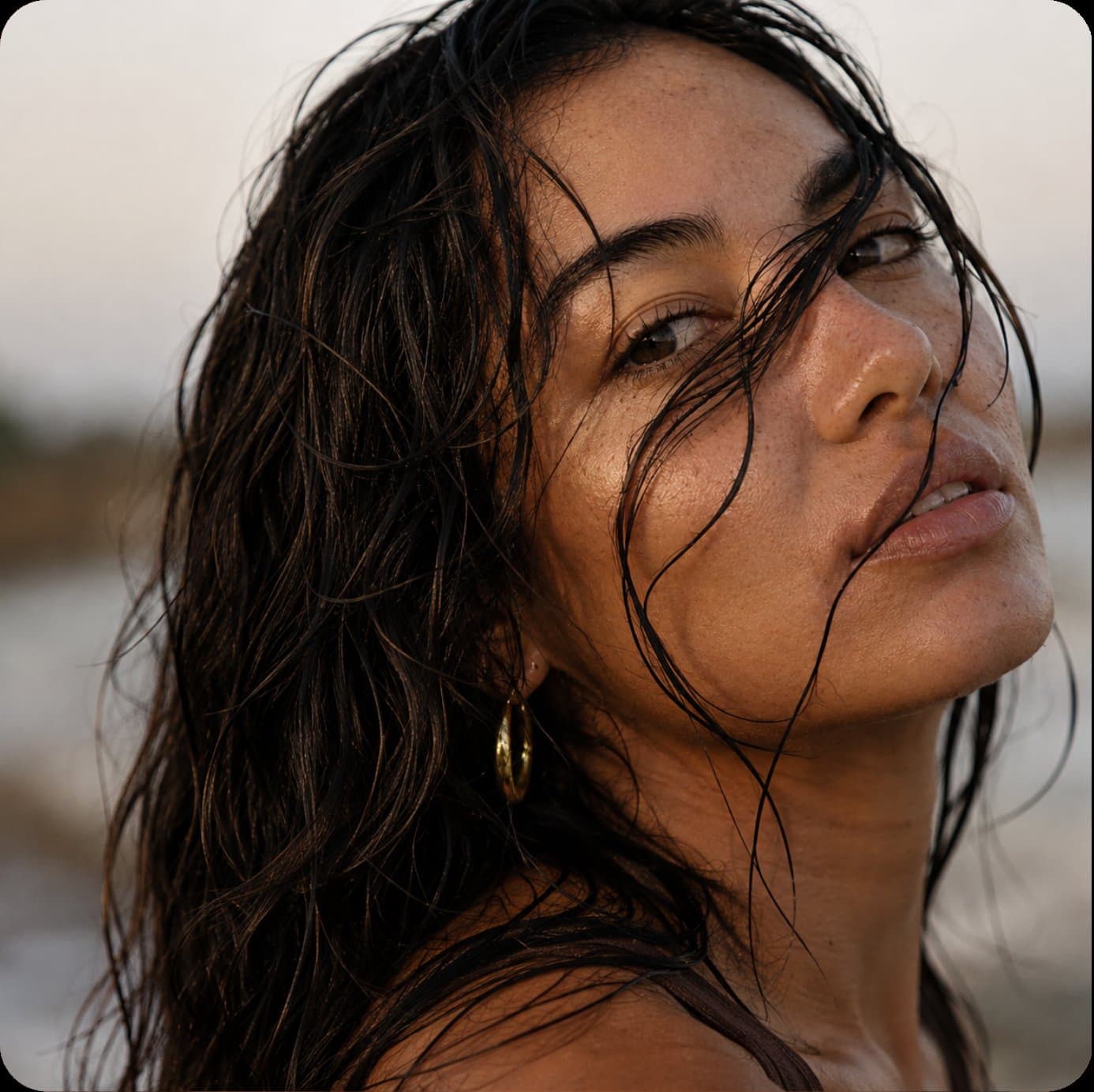 A woman with wet hair at the shoreline