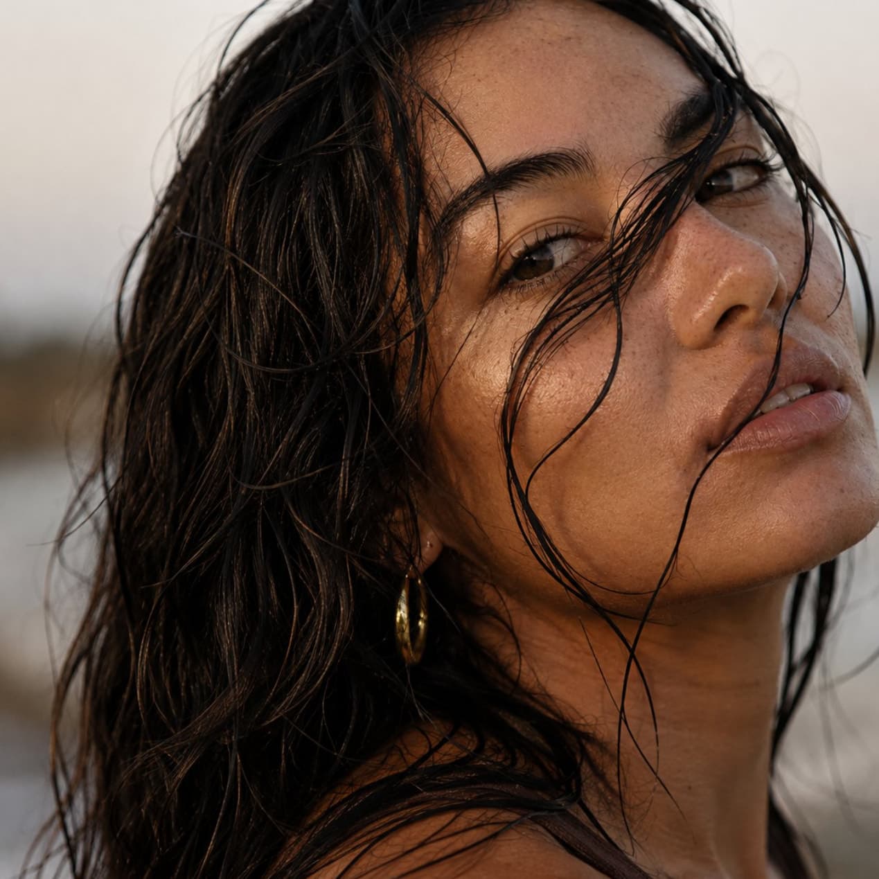 A woman with wet hair at the shoreline