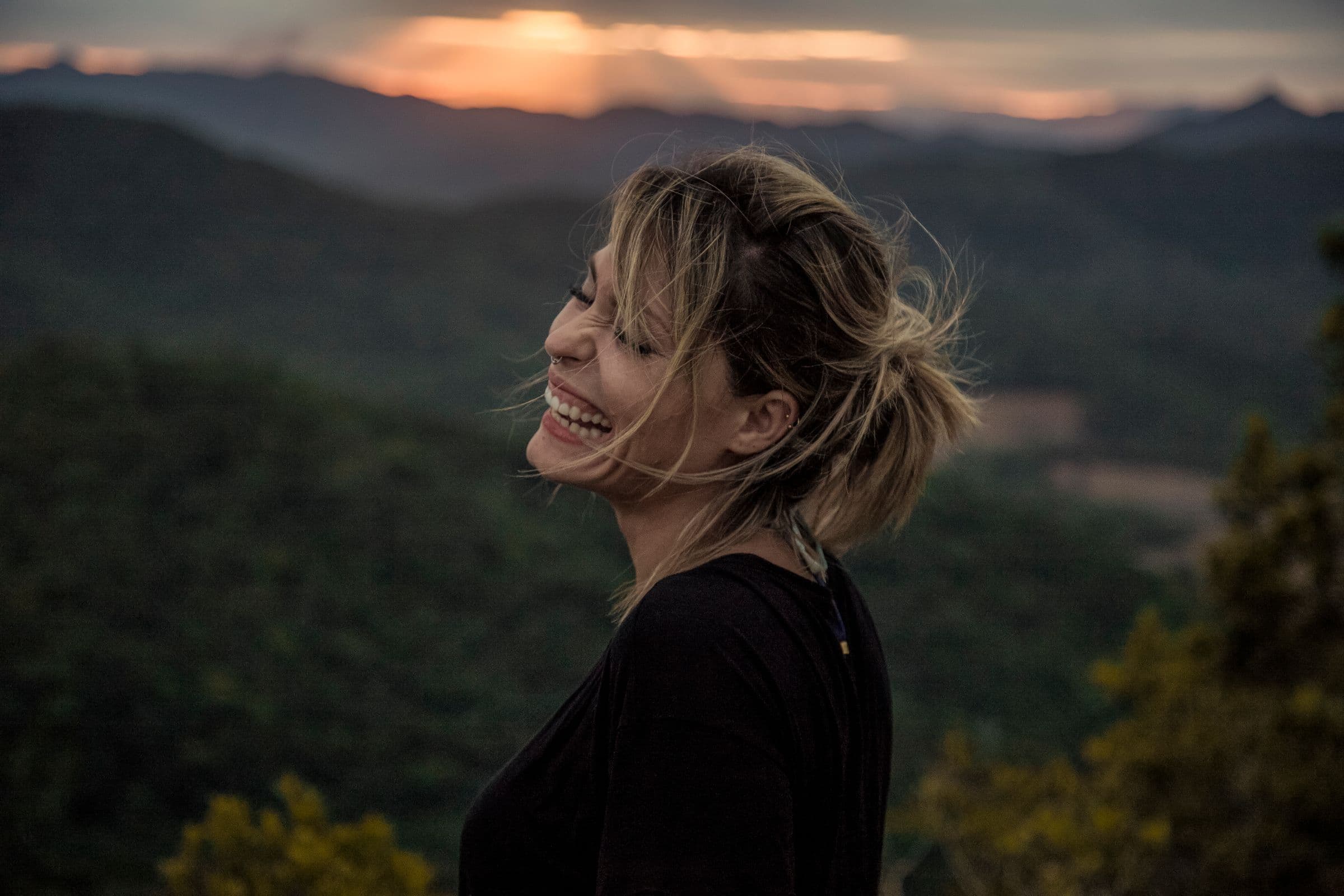 A woman laughing outdoors at sunset, opening what midlife women should know about GLP-1s and menopause weight gain