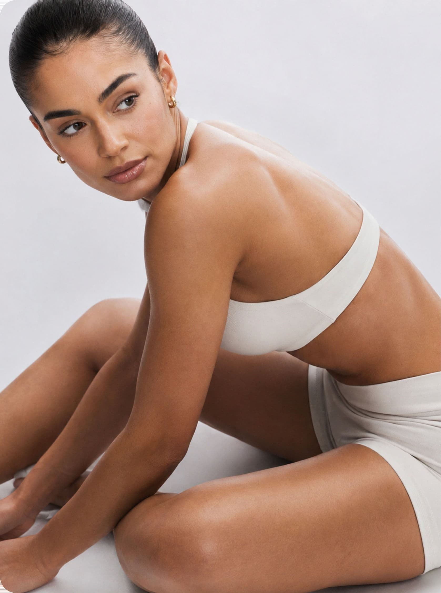 A woman sitting, looking over her shoulder