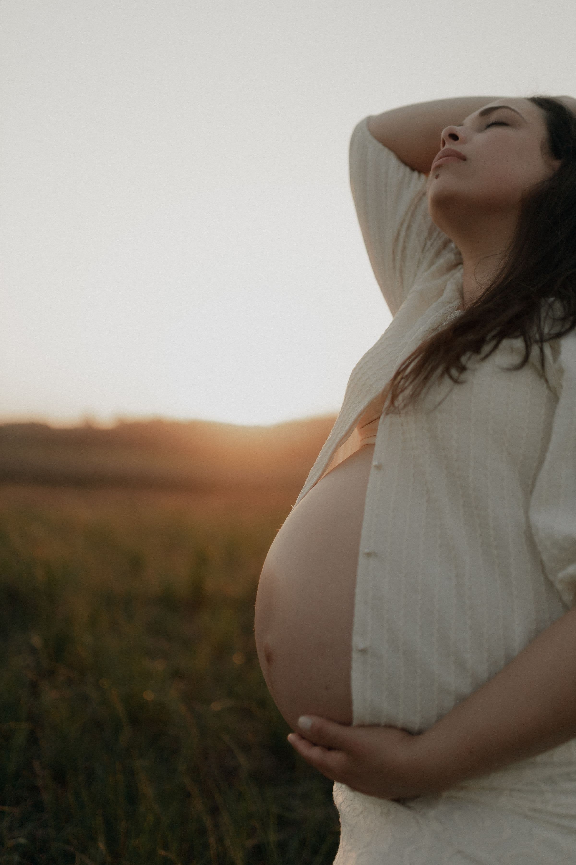 A pregnant woman in a field at sunset, opening what women should know about GLP-1s, fertility and Ozempic babies