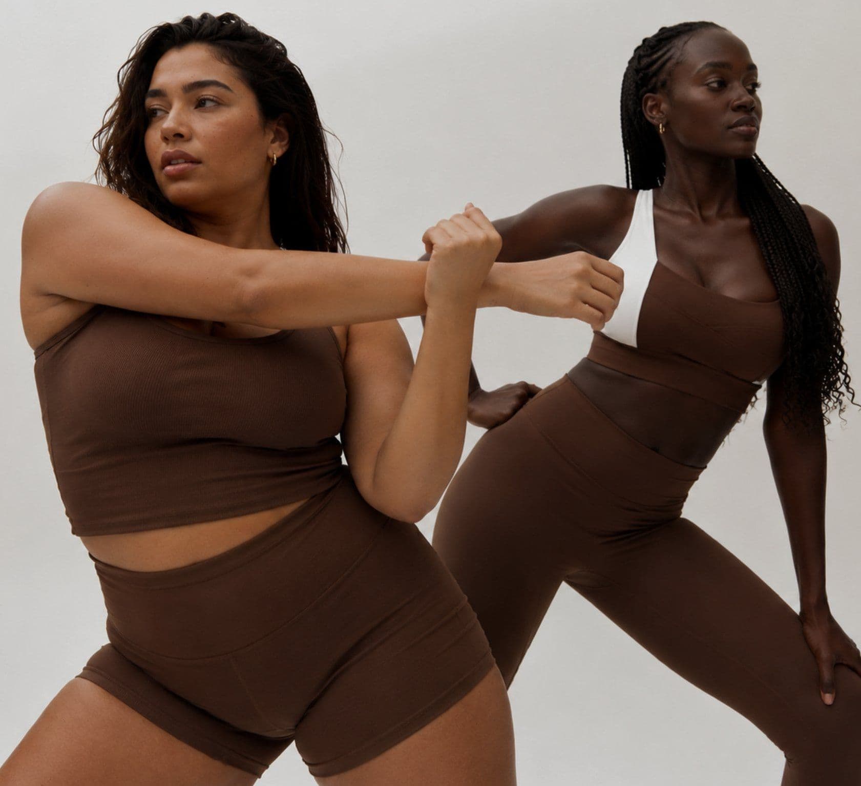 Two women stretching in brown activewear