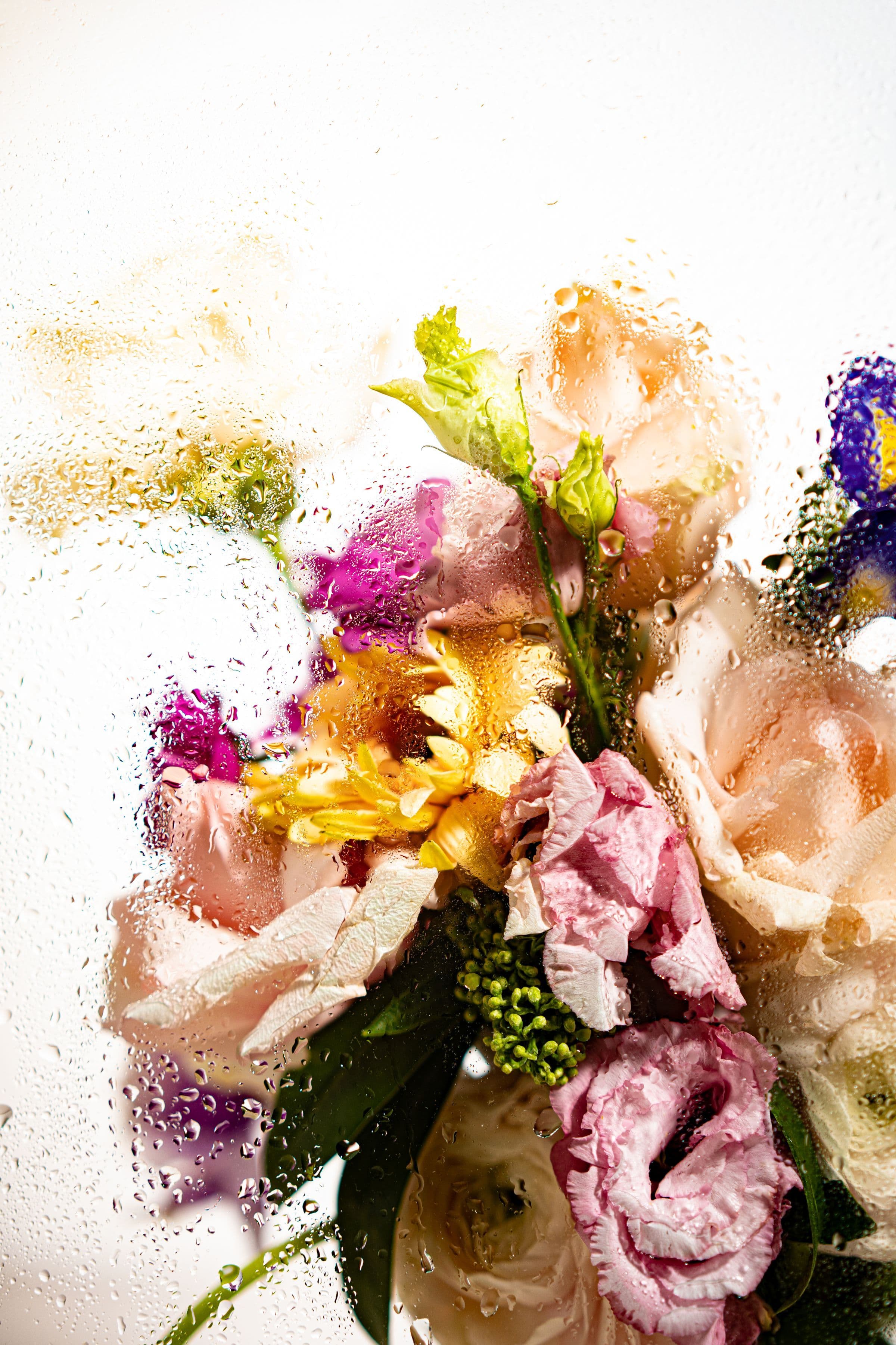 A bouquet of pastel flowers behind misted glass, opening a guide to microdosing GLP-1s in perimenopause and menopause