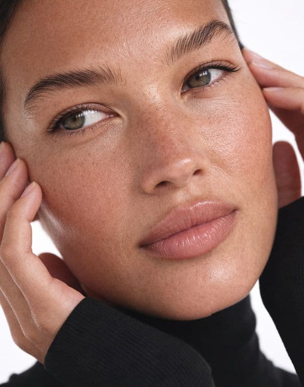 A woman resting her hands against her face