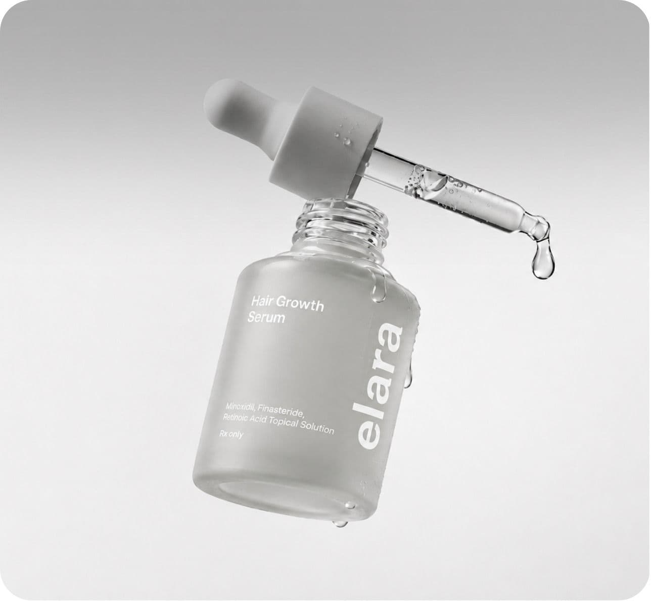 A frosted Elara Hair Growth Serum bottle with its dropper above it