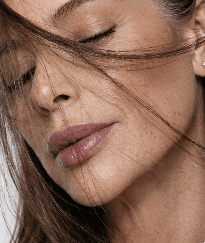 A woman with hair falling across her face, eyes closed