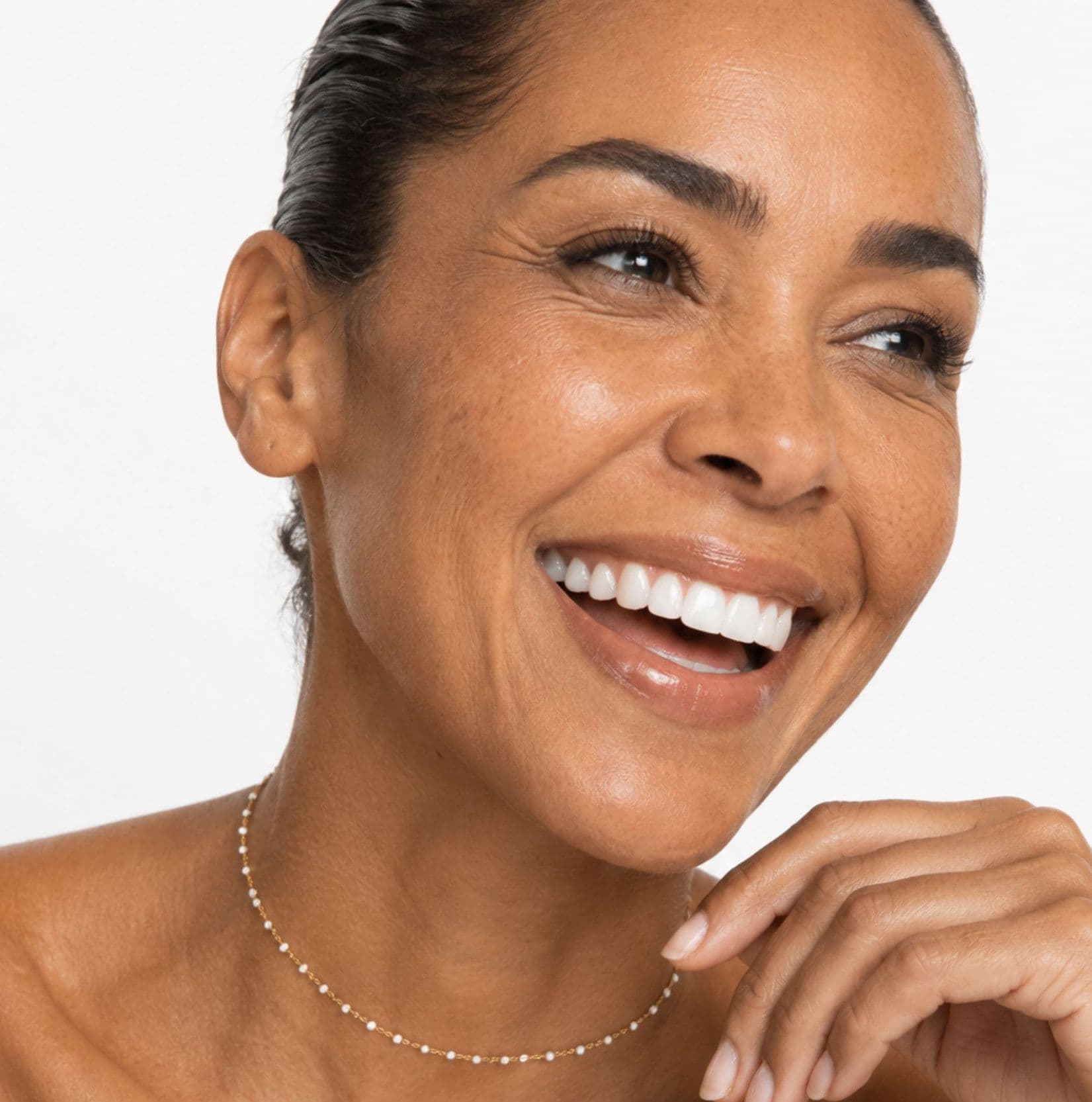 A smiling woman resting her hand under her chin