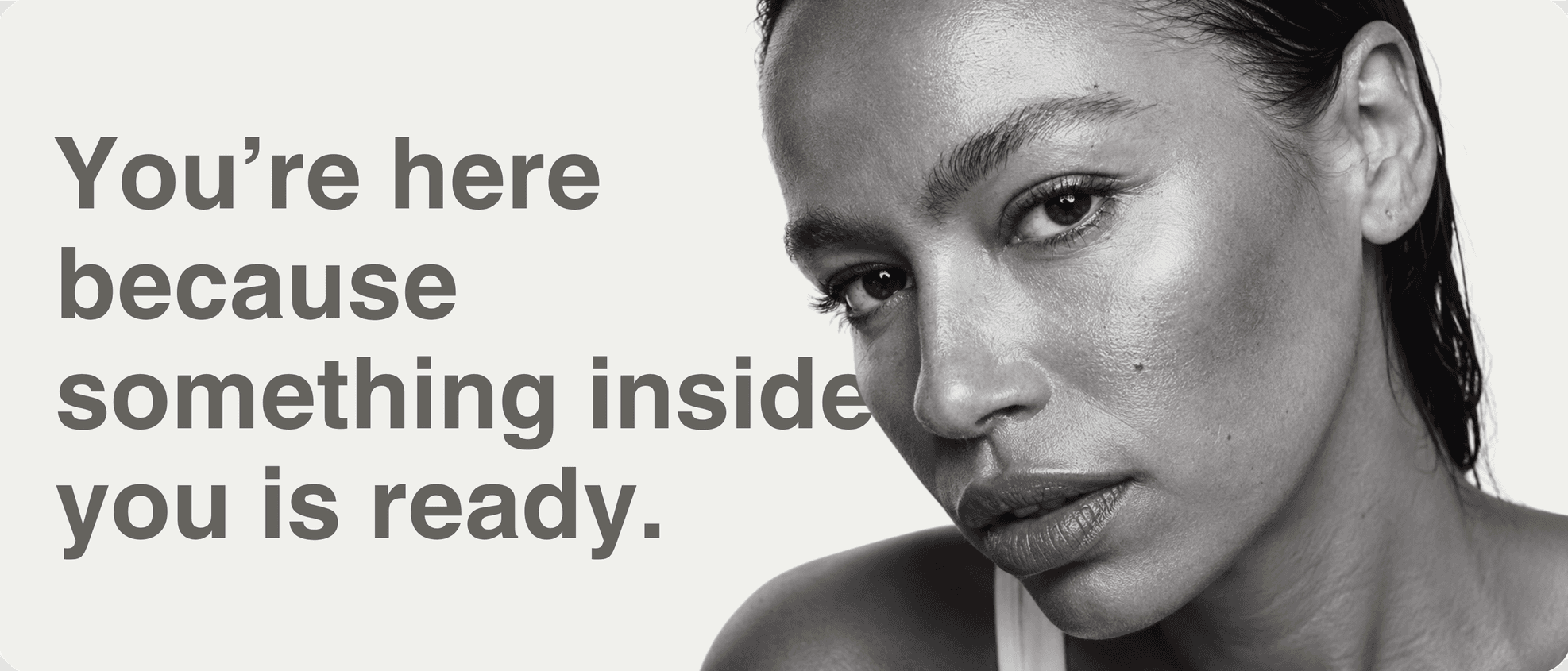 You’re here because something inside you is ready. A black and white portrait of a woman looking into the camera.