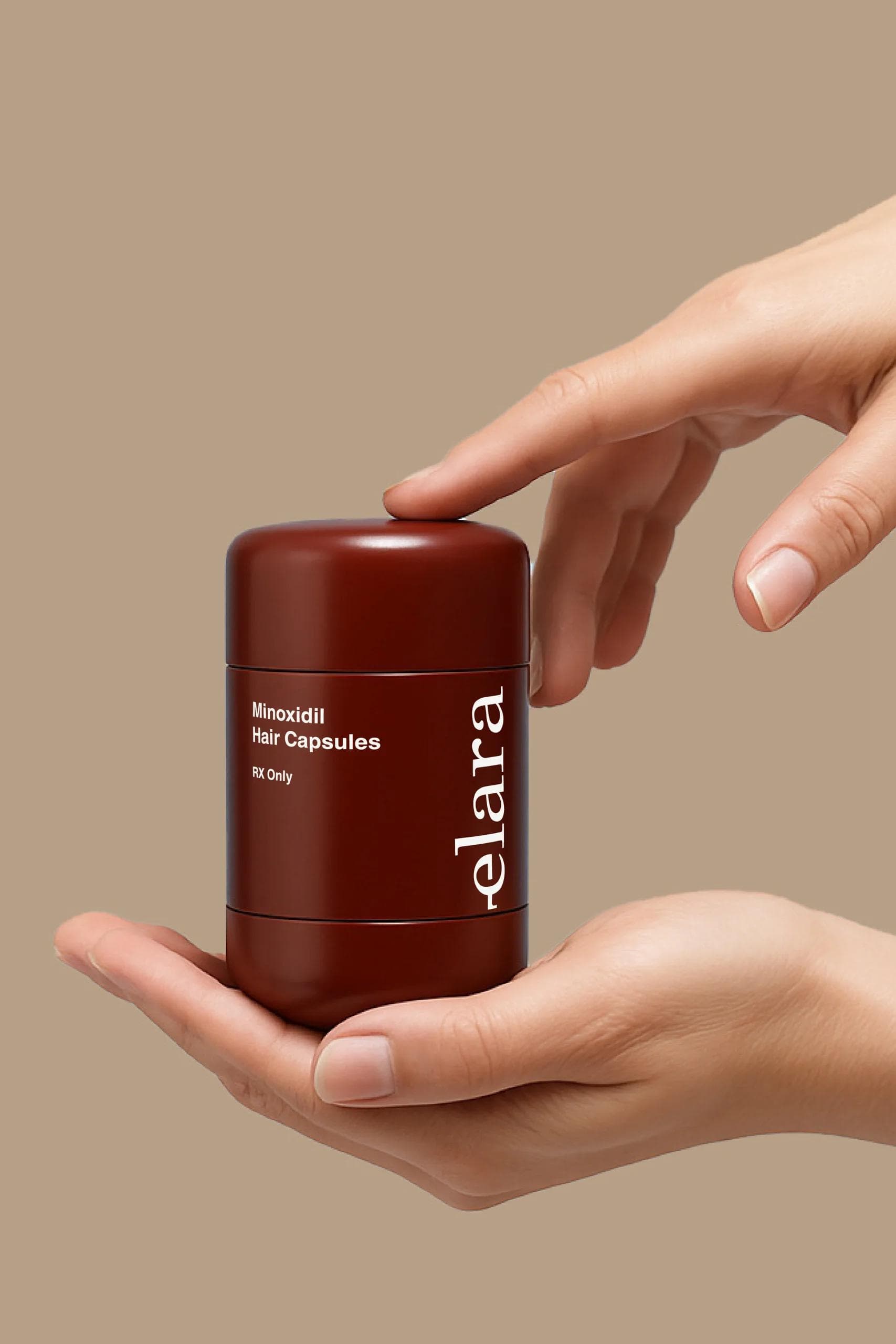 Hands holding the elara Minoxidil Hair Capsules canister