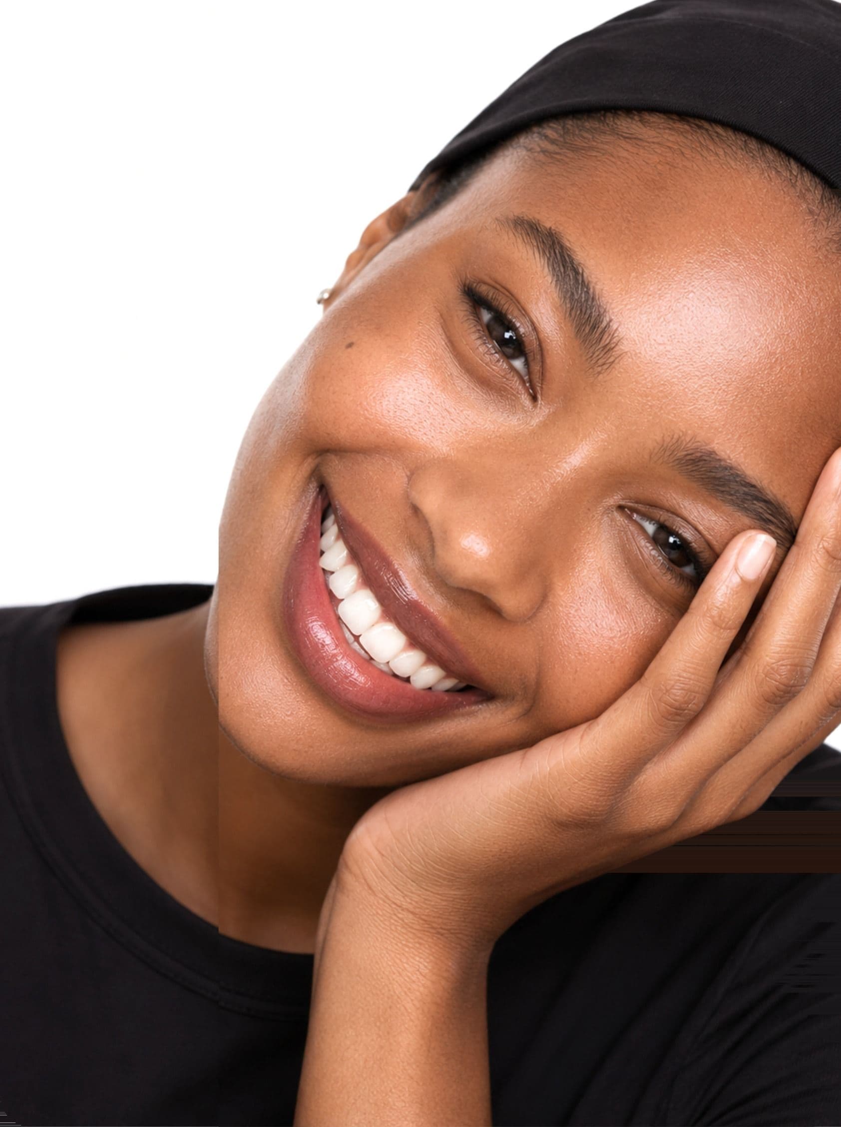 A woman smiling, her cheek on her hand
