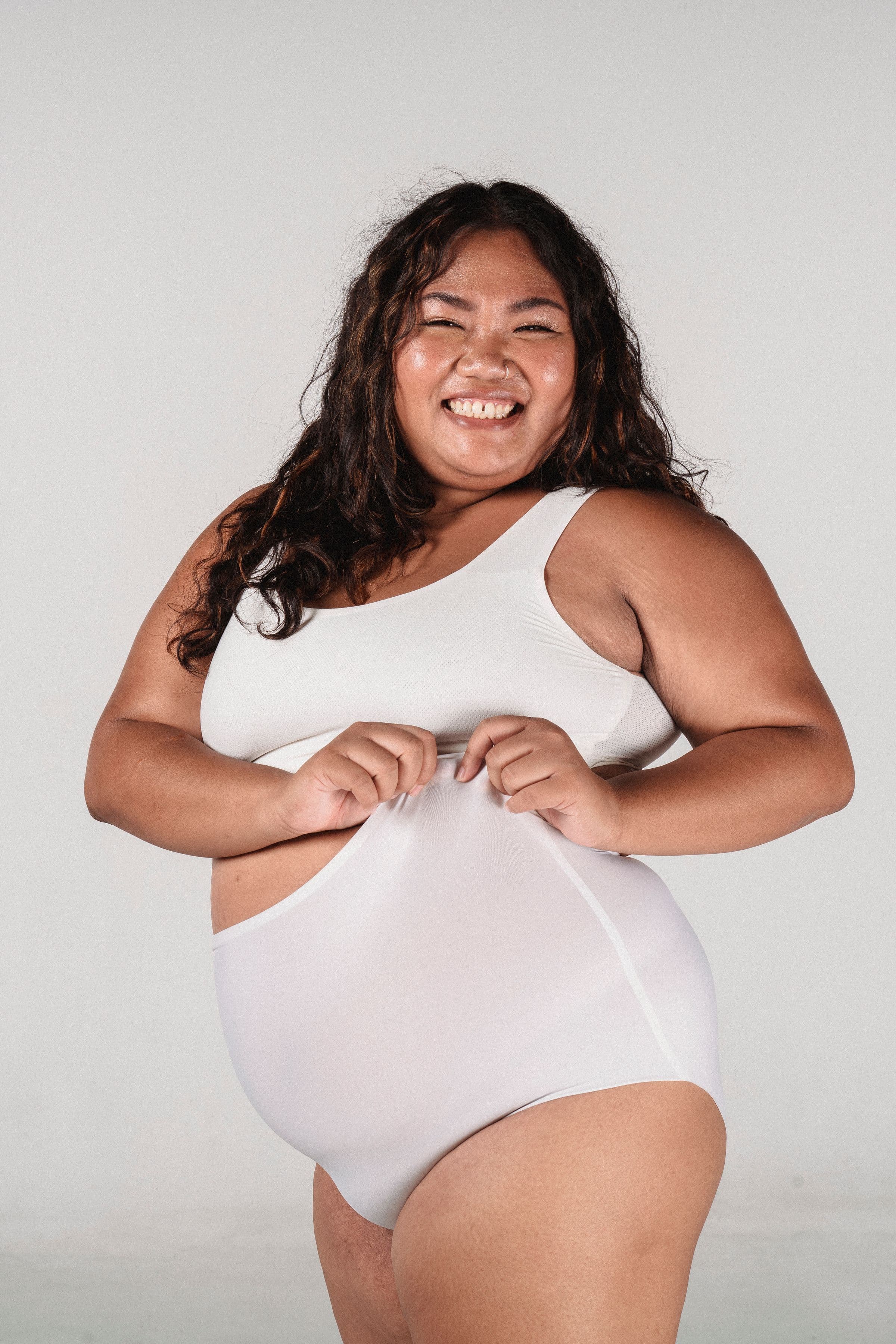 A smiling woman in a white bodysuit, opening a breakdown of what compounded semaglutide costs per month