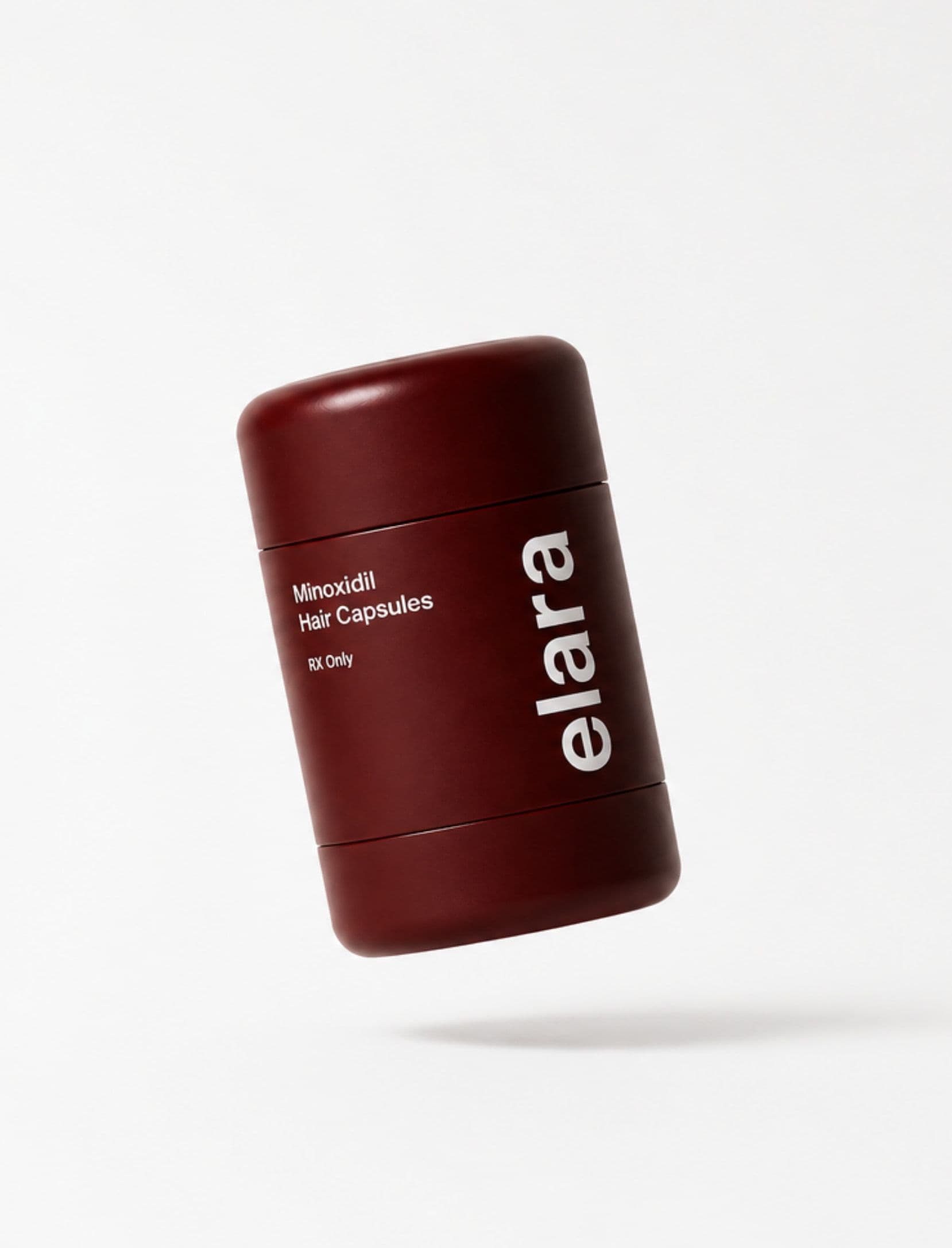Hands holding the elara Minoxidil Hair Capsules canister