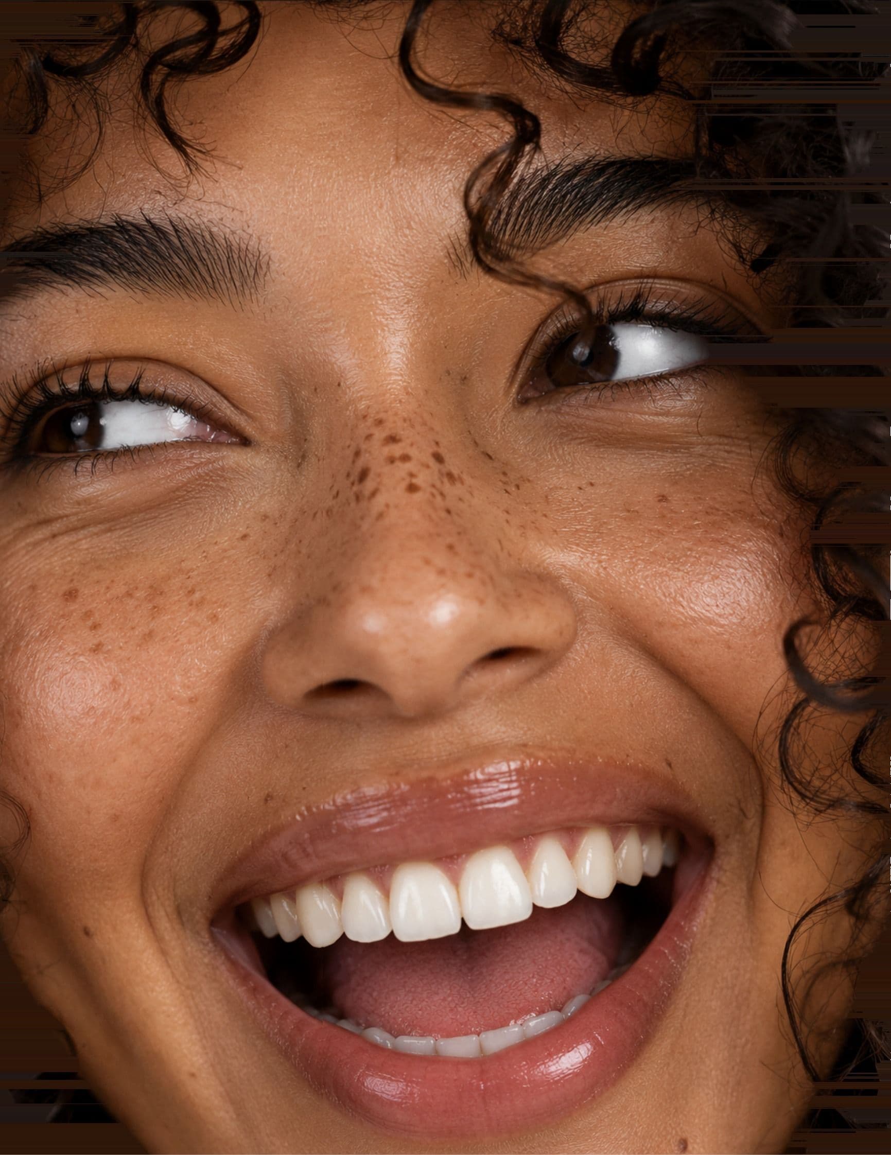A woman laughing, looking up